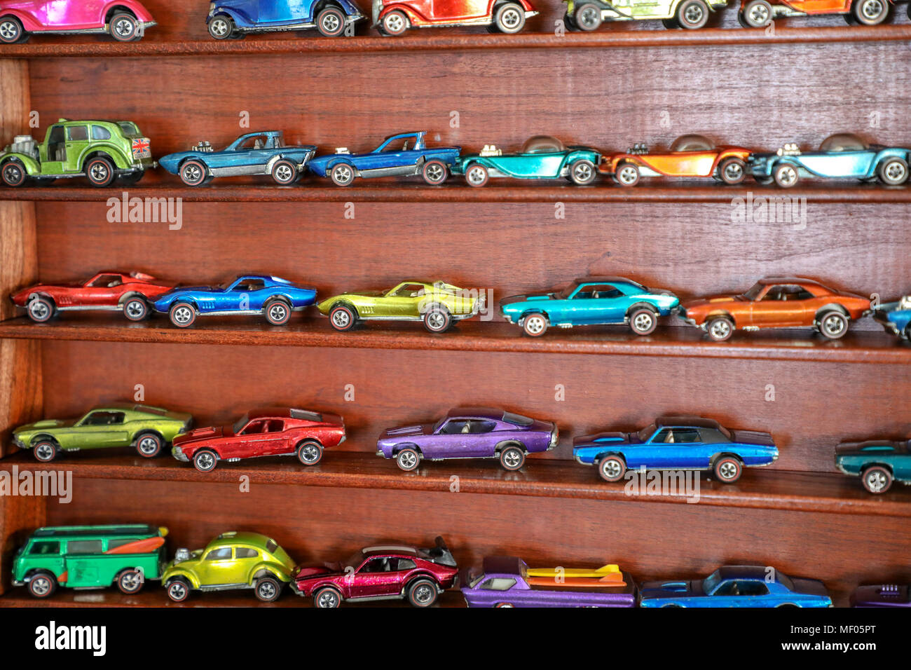 Multi colored Redline Hot Wheels in a cherry display case. Stock Photo