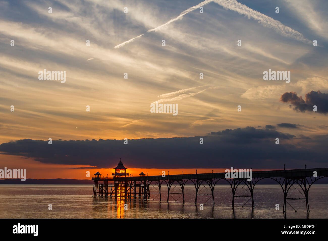 Clevedon Pier at Sunset with a streak of orangey reddish sunlight going through the Pier head Stock Photo