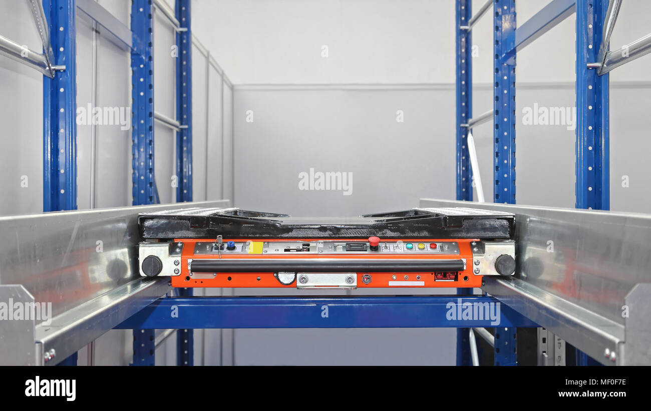 Automated Pallet Shuttle Transport at Shelves in Warehouse Stock Photo