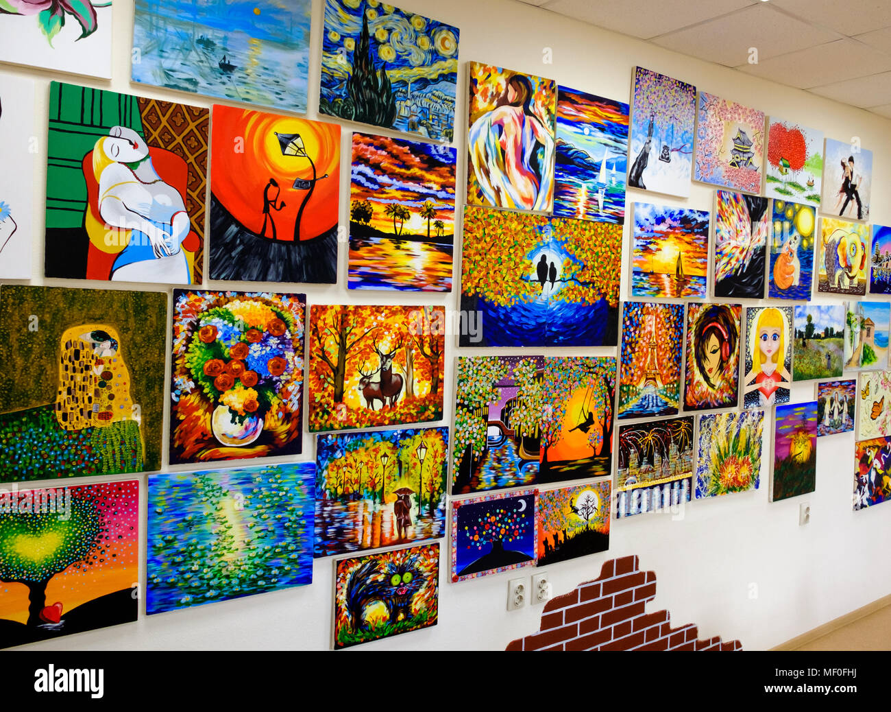 KIROV, RUSSIA - AUGUST 7, 2017: Many beautiful vibrant paintings on the wall of a local art studio, originals and replicas Stock Photo