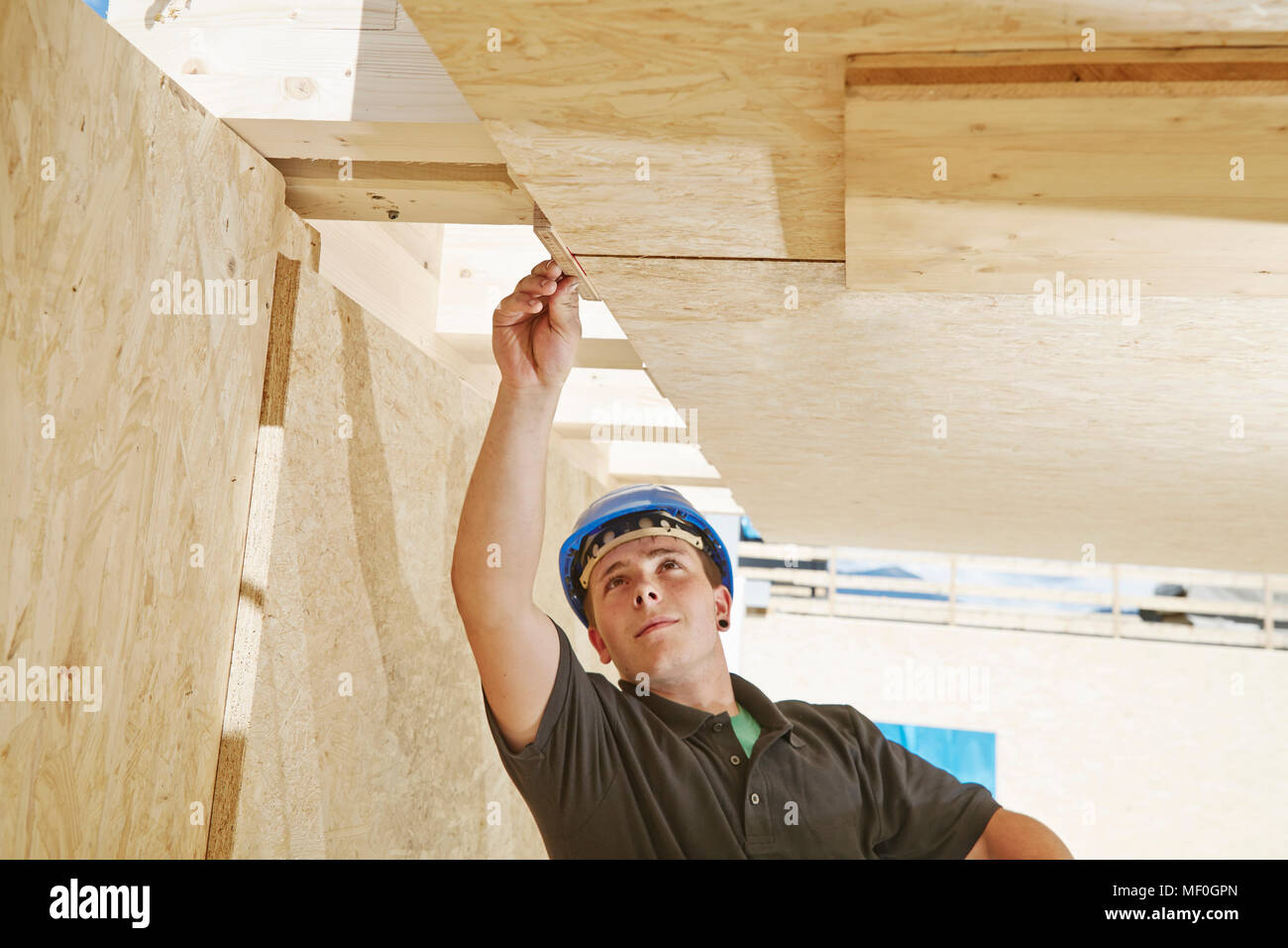 Austria, worker checking roof construction Stock Photo