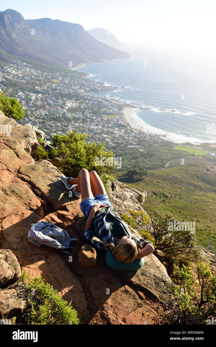 South Africa, Cape Town, woman lying on rock during hiking trip to Lion's Head Stock Photo