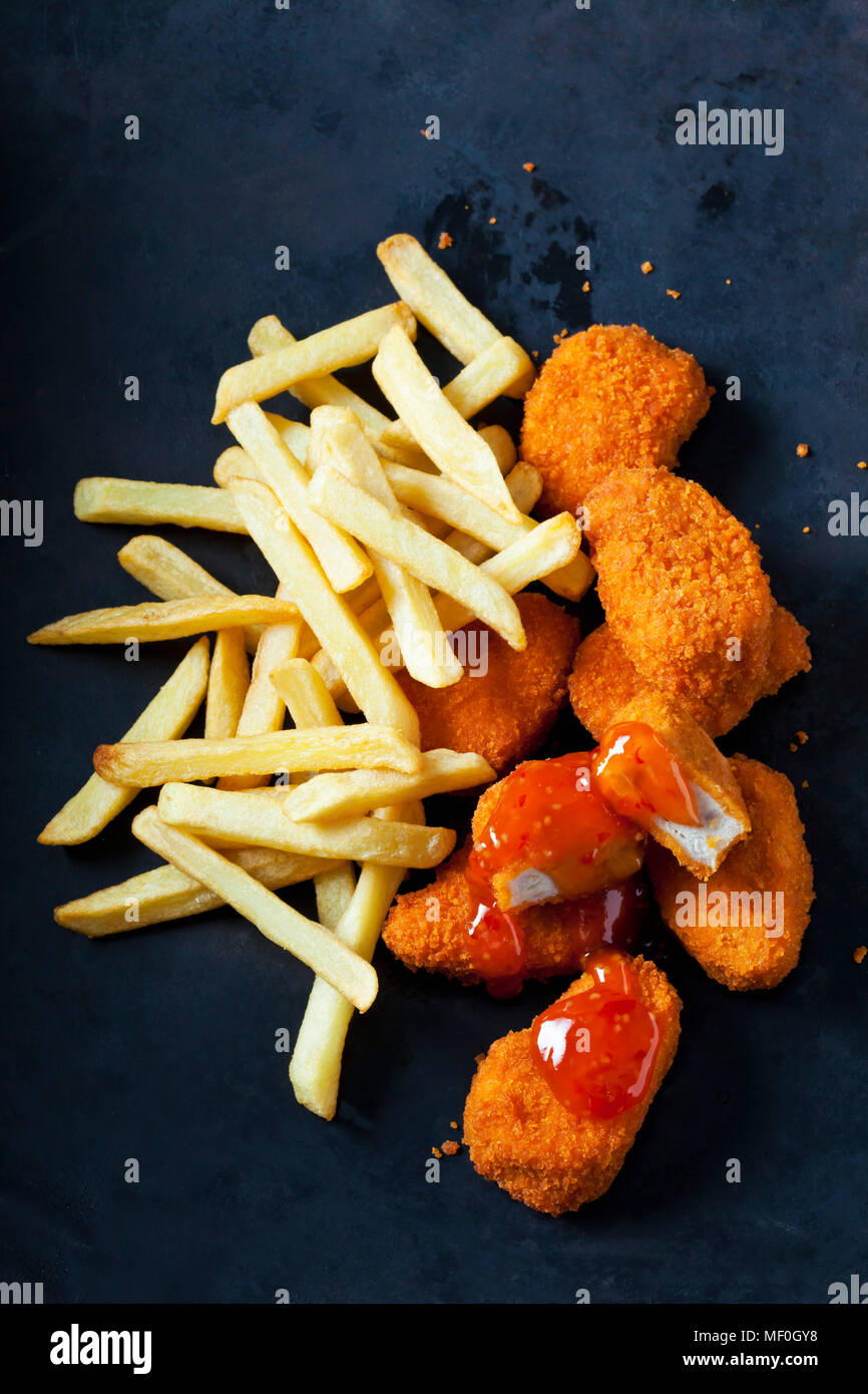 Chicken Nuggets with sweet chili sauce and French Fries on dark ground Stock Photo