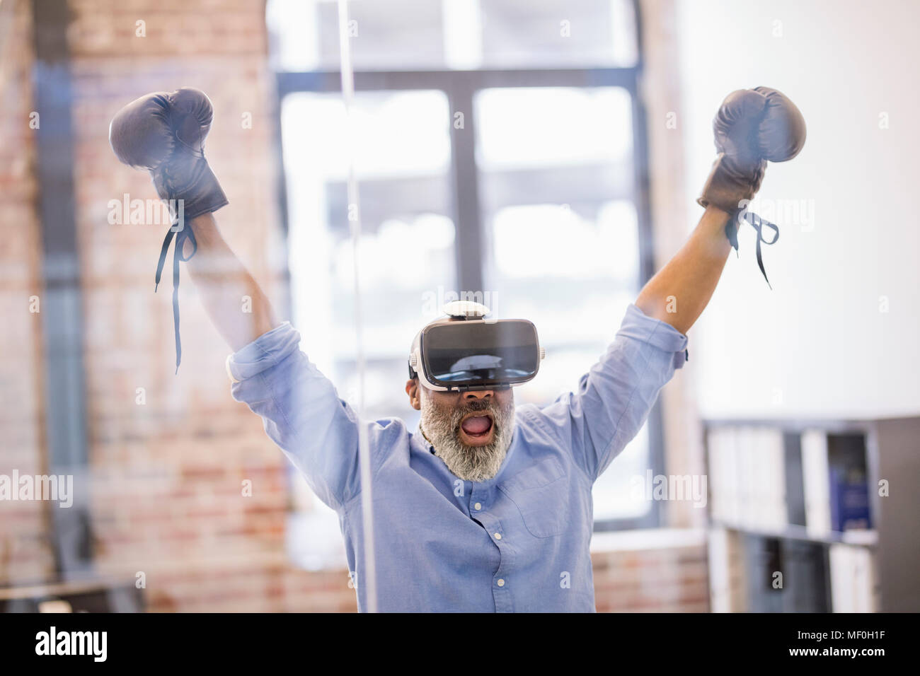 Portrait of businessman with Virtual Reality Glasses and boxing gloves in the office Stock Photo