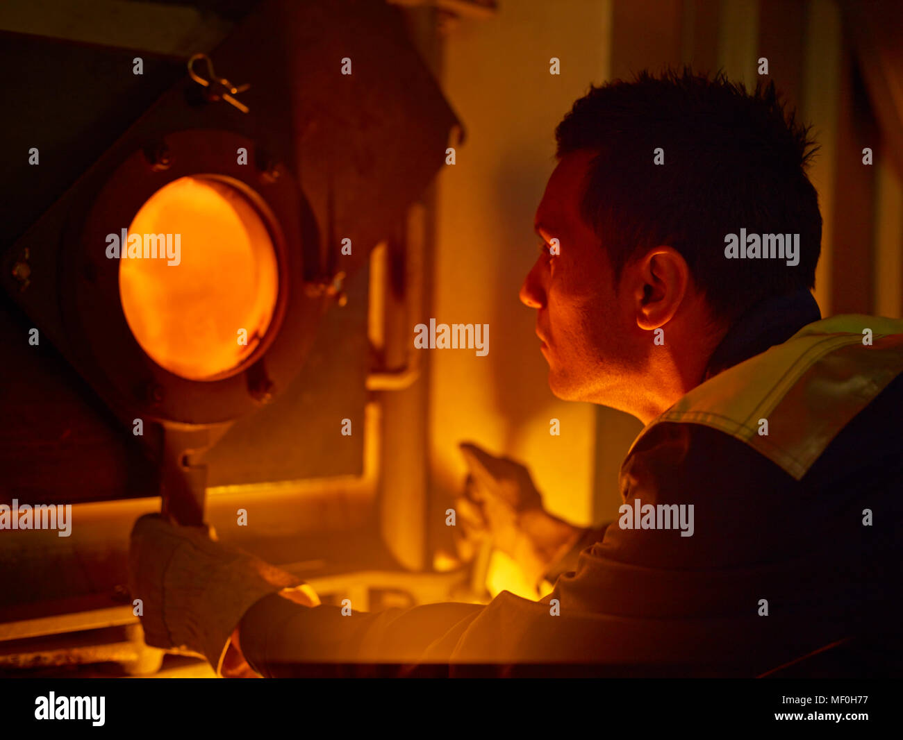 Worker controlling of combustion in furnace Stock Photo