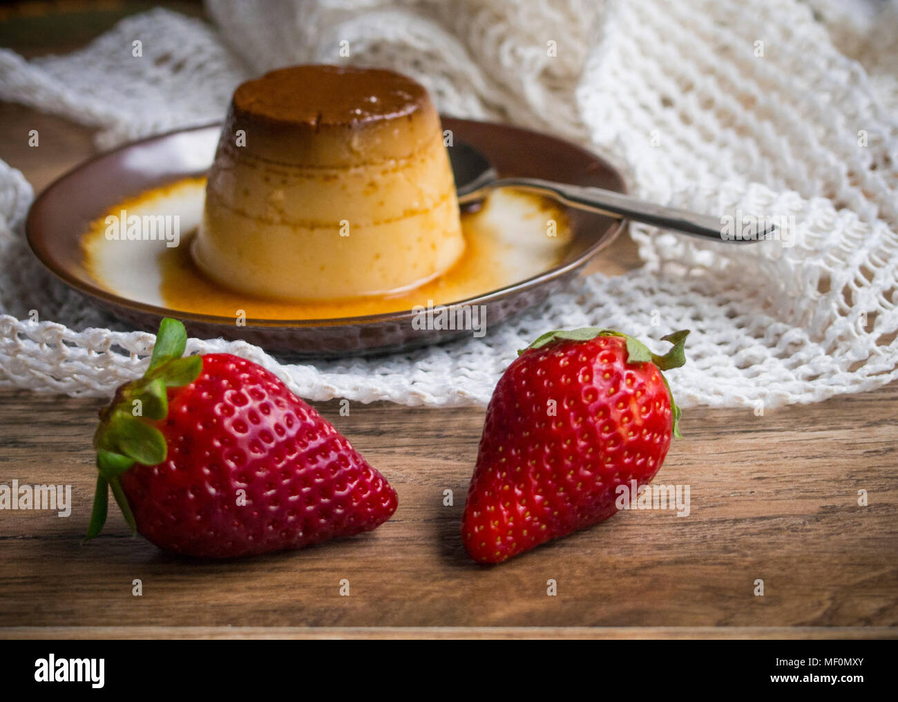 Flan in a plate on wood background Stock Photo