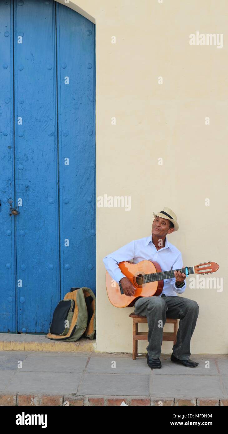 Cuban man with hat playing acoustic guitar in a town square, Trinidad, Cuba Stock Photo