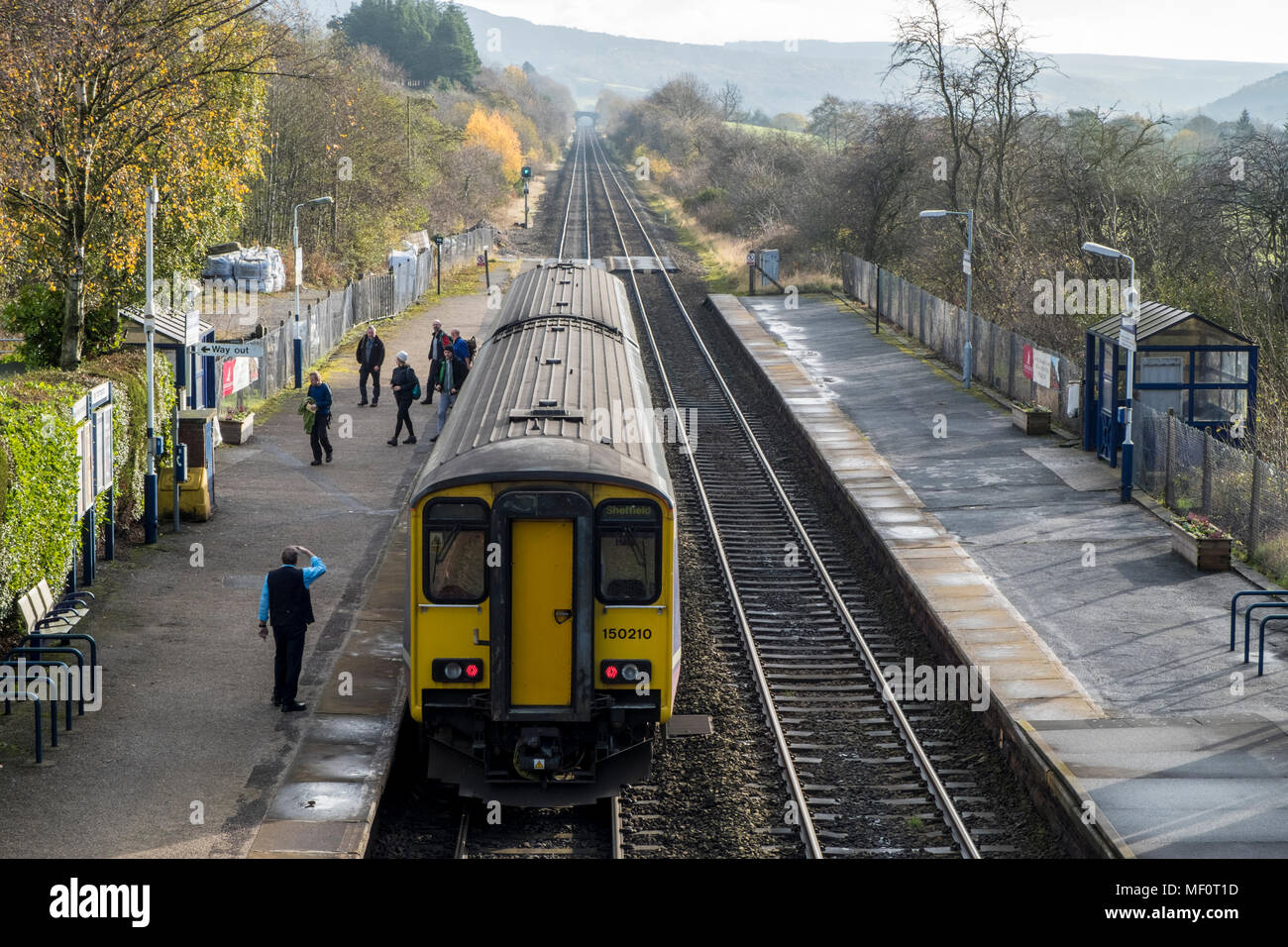 Passengers leaving a train at the rural railway station of Bamford in the Derbyshire countryside, Peak District, England, UK Stock Photo