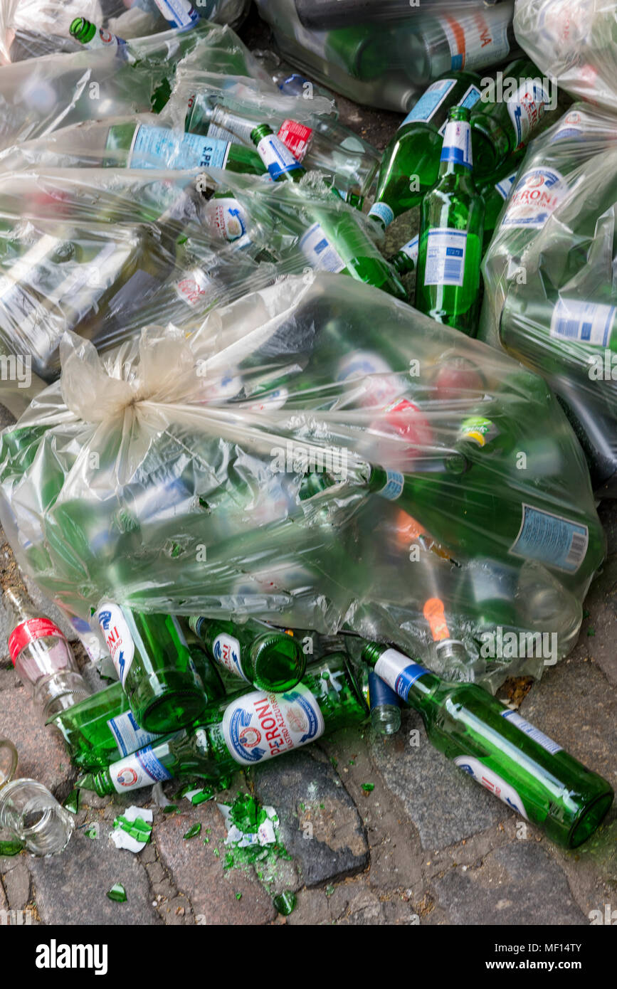 a quantity of green glass bottles in a see through plastic bag ready