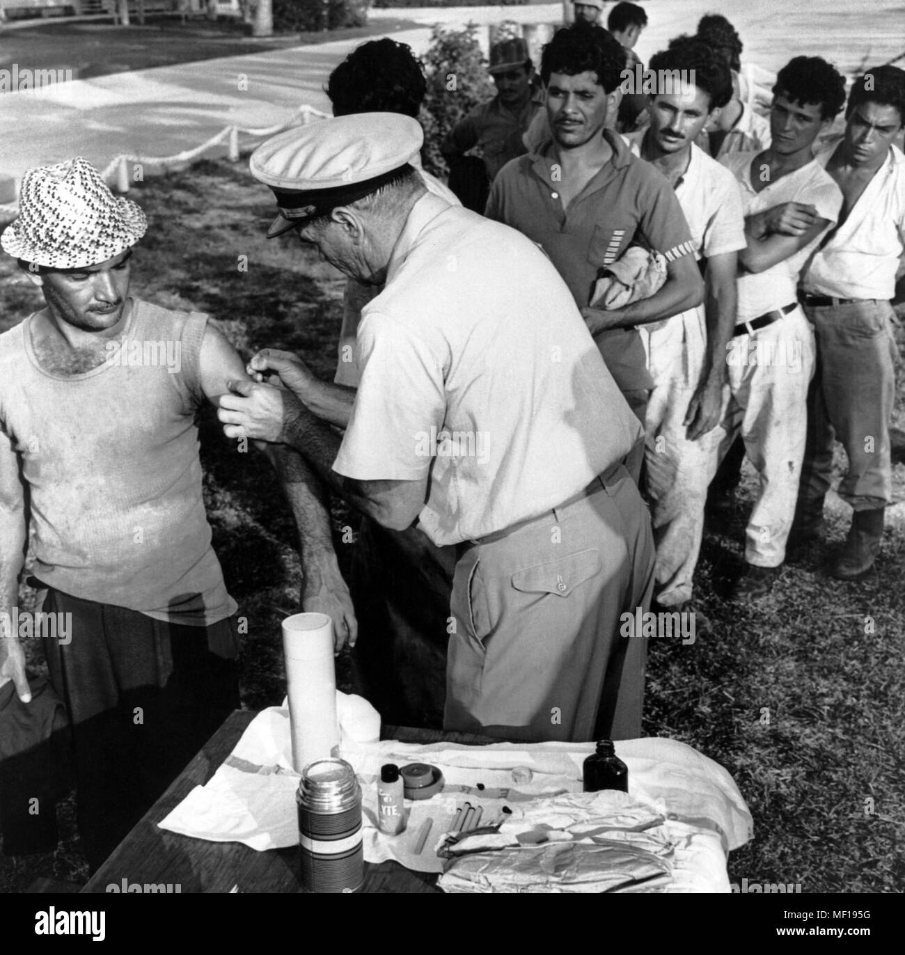 U.S. Public Health Service (PHS) representative immunizing a Cuban man, Cuban mass-emigration, Miami, Florida, October, 1965. Image courtesy Centers for Disease Control (CDC). () Stock Photo