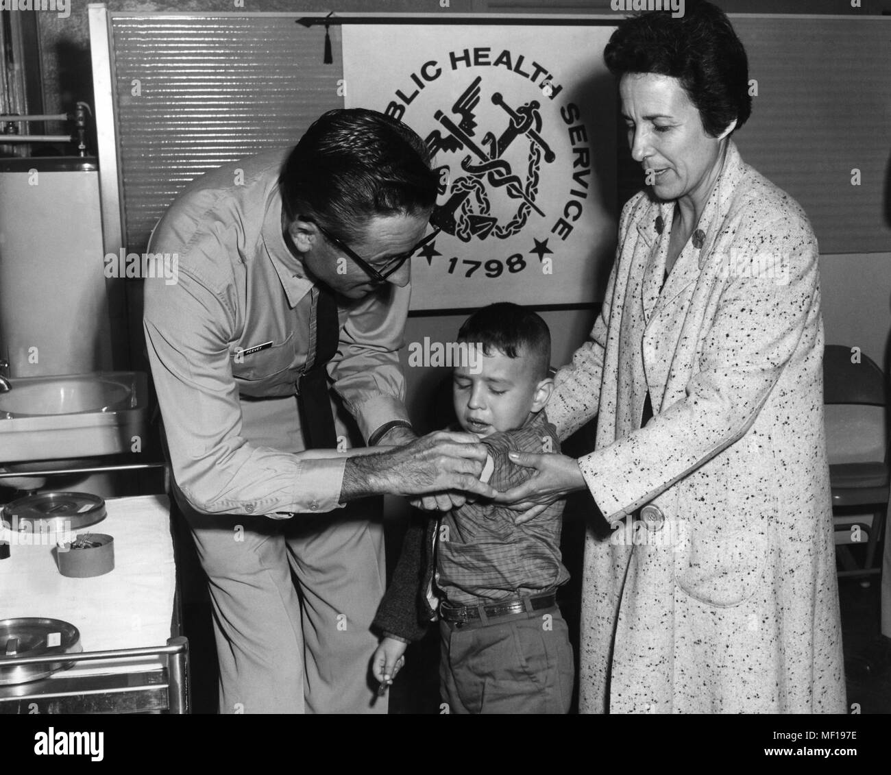 U.S. Public Health Service (PHS) representative immunizing a Cuban boy, Cuban mass-emigration, Miami, Florida, October, 1965. Image courtesy Centers for Disease Control (CDC). () Stock Photo