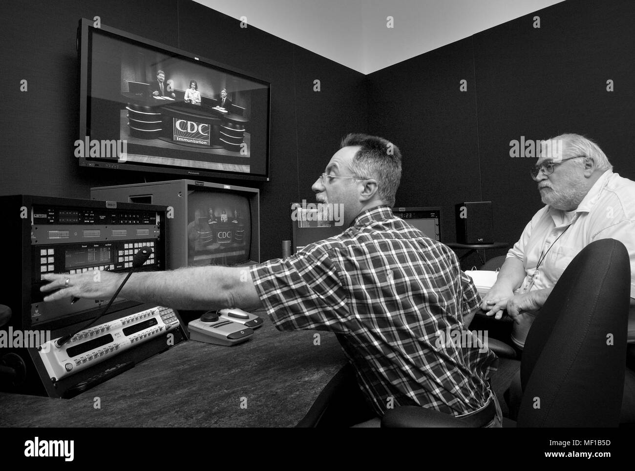 Two studio workers monitoring television transmission at Centers for Disease Control (CDC) Division of Creative Services, Roybal Campus, Clifton Road, Atlanta, Georgia, 2005. Image courtesy Centers for Disease Control. () Stock Photo