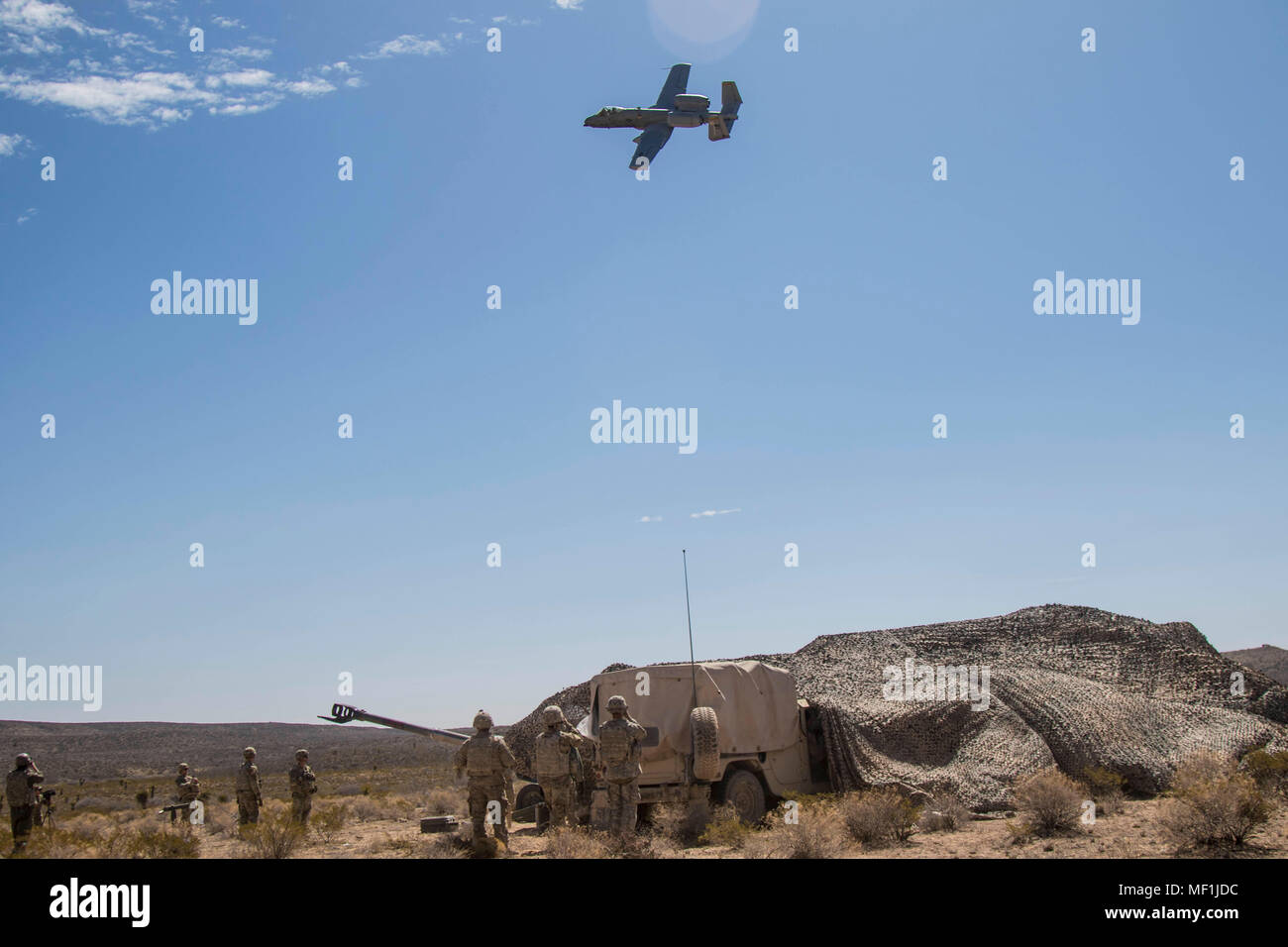 A-10 Thunderbolt IIs Airplane flies over artillerymen with Charlie Battery, 2nd Battalion, 3rd Field Artillery, 1st Brigade, 1st Armored Division at Orogrande, Range Complex, New Mexico, on April 19, 2018. Hustler Trough is a week long exercise hosted by 2-3 FA artillerymen with Air Force pilots from the 66th Weapons Squadron, United States Air Force Weapons School, Nellis Air Force Base, Nevada to test operational effectiveness between the Army and Air Force. (U.S. Army photo by Sgt. Alon Humphrey) Stock Photo