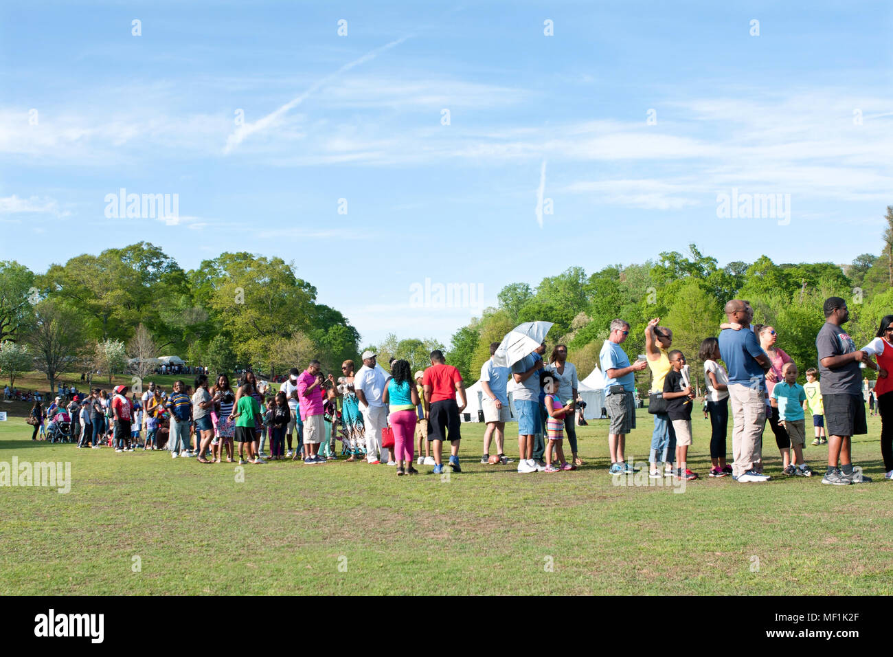 A line of parents waits with their kids for their turn on the bungee jumping ride at the Atlanta Dogwood Festival on April 11, 2015 in Atlanta, GA. Stock Photo
