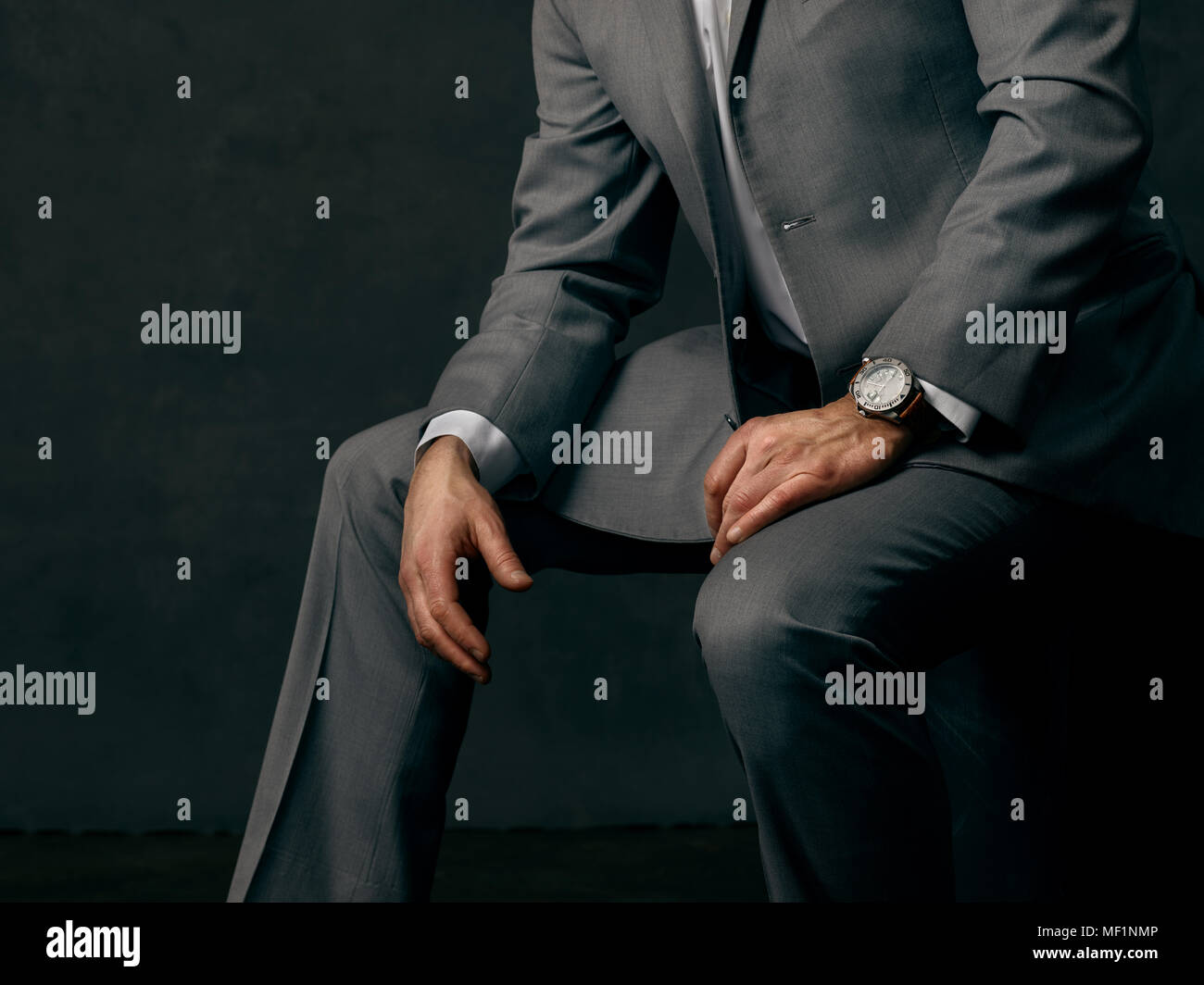 Man in a business suit, wearing a watch, in various positions. Stock Photo