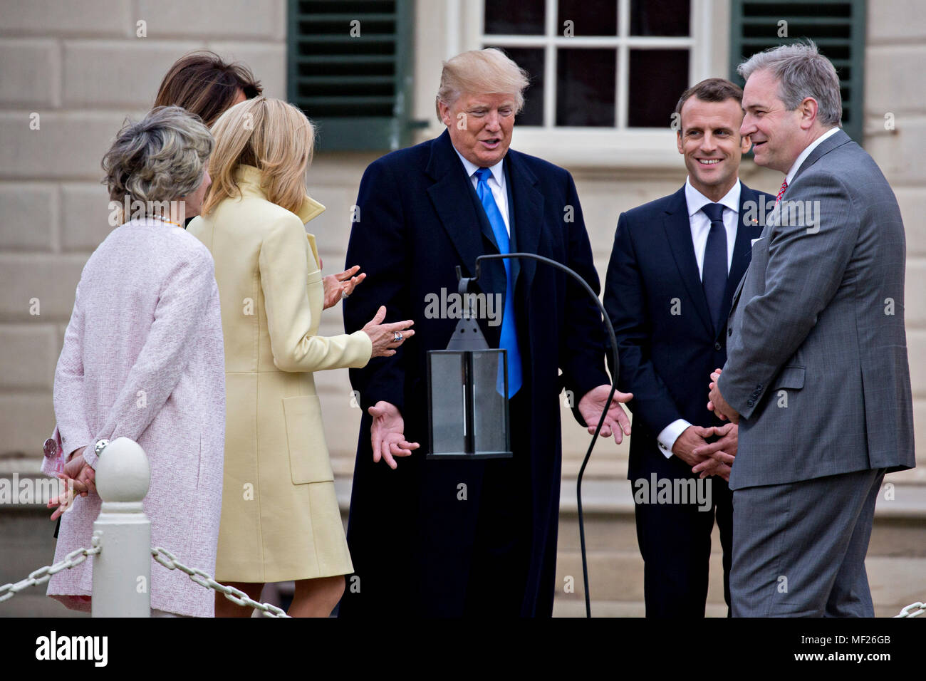 U.S. President Donald Trump, center, speaks as Doug Bradburn, president and chief executive officer of George Washington's Mount Vernon, from right, Emmanuel Macron, France's president, Brigitte Macron, France's first lady, U.S. First Lady Melania Trump and Sarah Miller Coulson, regent with the Mount Vernon Ladies' Association, listen while touring outside the Mansion at the Mount Vernon estate of first U.S. President George Washington in Mount Vernon, Virginia, U.S., on Monday, April 23, 2018. As Macron arrives for the first state visit of Trump's presidency, the U.S. leader is threatening to Stock Photo
