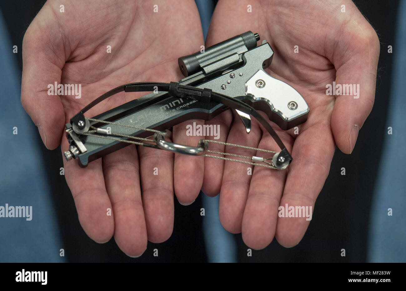 24 April 2018, Germany, Frankfurt/Main: An officer presents a miniature crossbow at the customs office's annual press conference. The item, originally from China, can shoot toothpicks and thin metal sticks across a distance of several metres with considerable force. The customs office has confiscated the weapon due to product security concerns. Photo: Boris Roessler/dpa Stock Photo