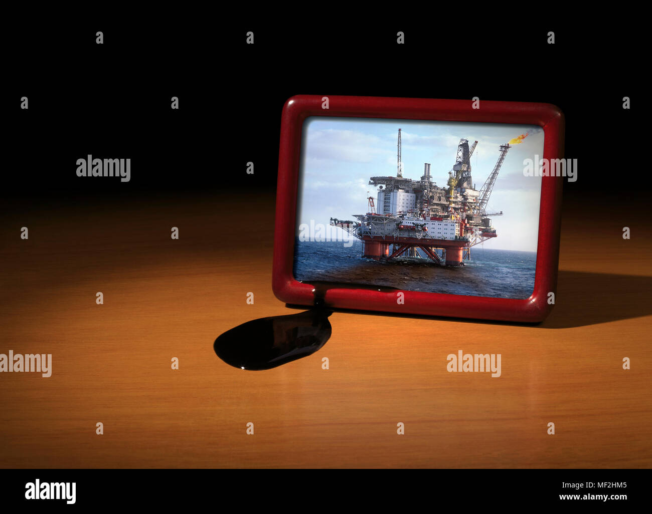 Picture of oil Platform on a desk with an oil Spill Stock Photo