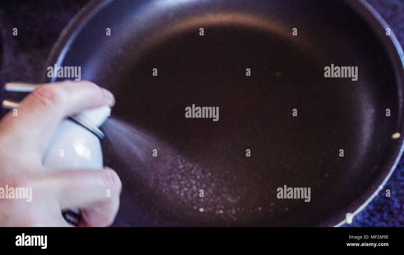 Step by step. Spraying cooking olive oil on frying pan to fry some