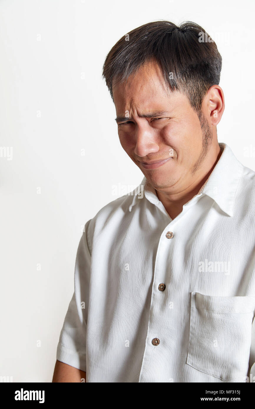 Young Adult man with a distasteful expression, wearing a white shirt isolated on white Stock Photo