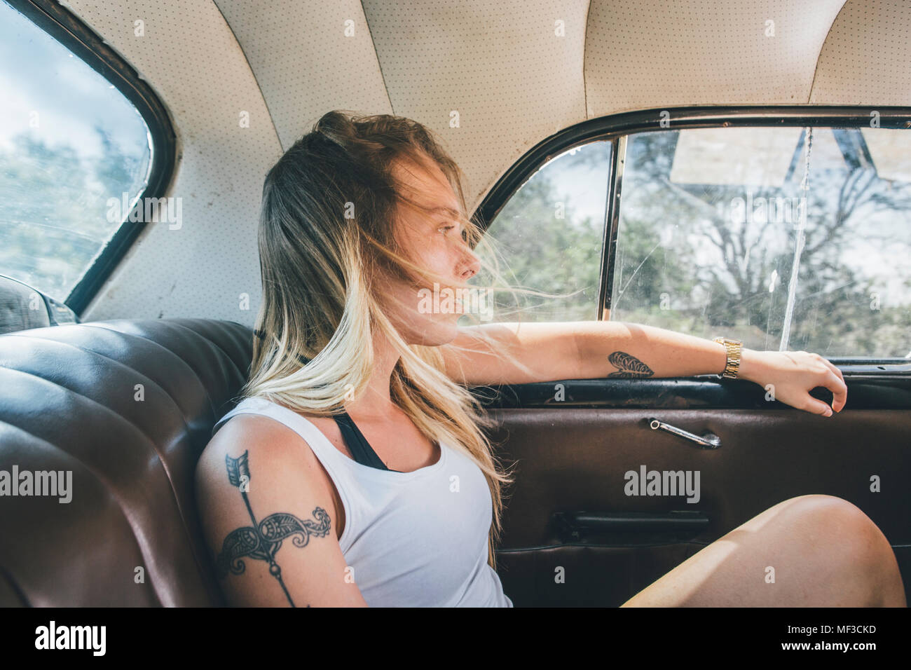 Cuba, Young woman sitting in a vintage car Stock Photo