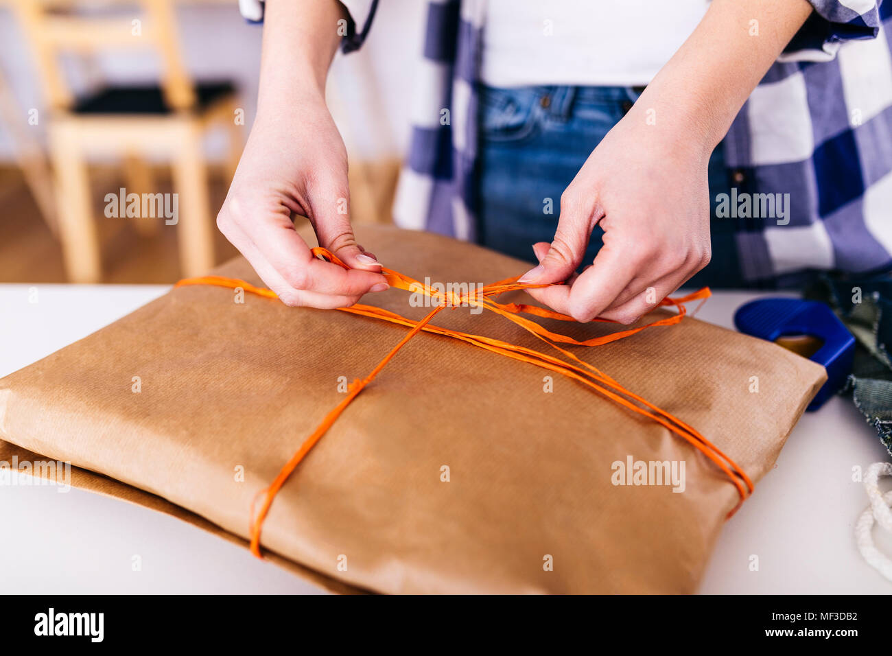 Close-up of woman wrapping a package Stock Photo