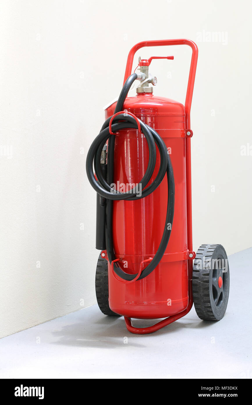 red fire extinguisher ready in case of emergency fire in a public building Stock Photo