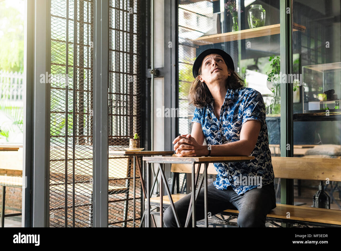 Artist sitting in a cafe, looking up Stock Photo