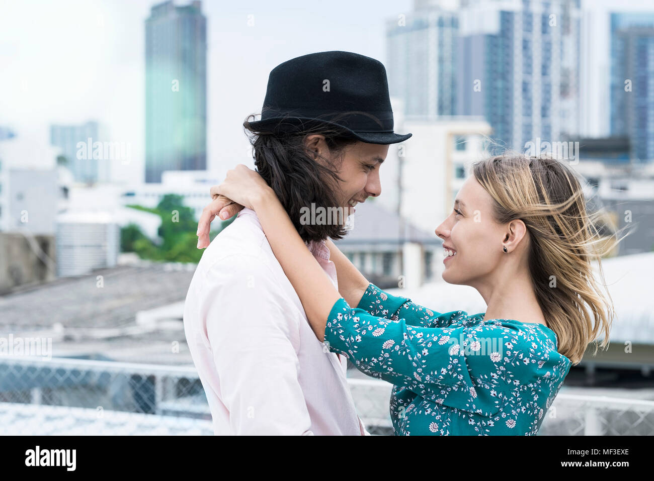 Young affectionate couple standing on rooftop Stock Photo