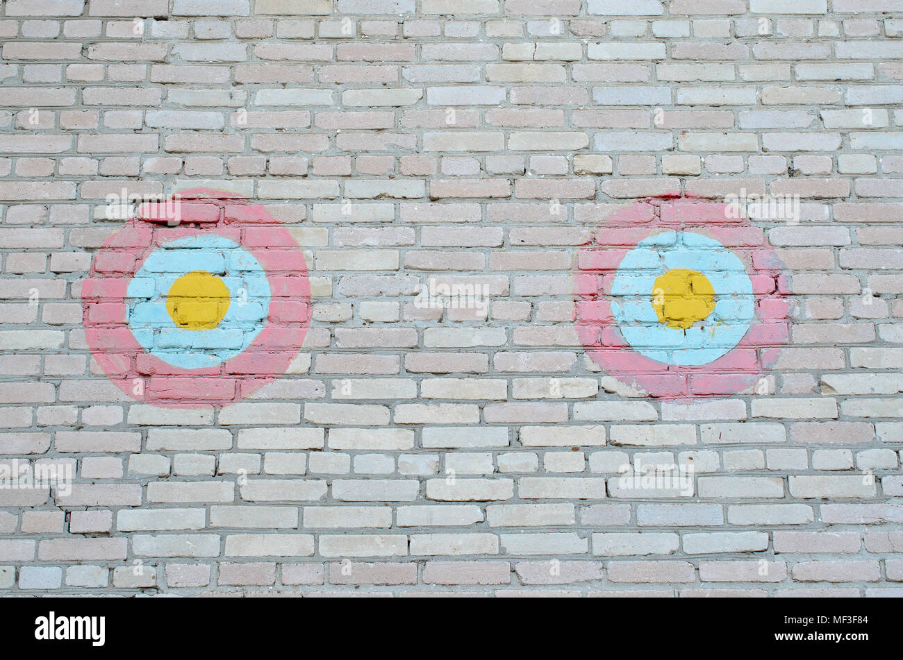 Two decorative red-blue-yellow circles on a brick wall Stock Photo