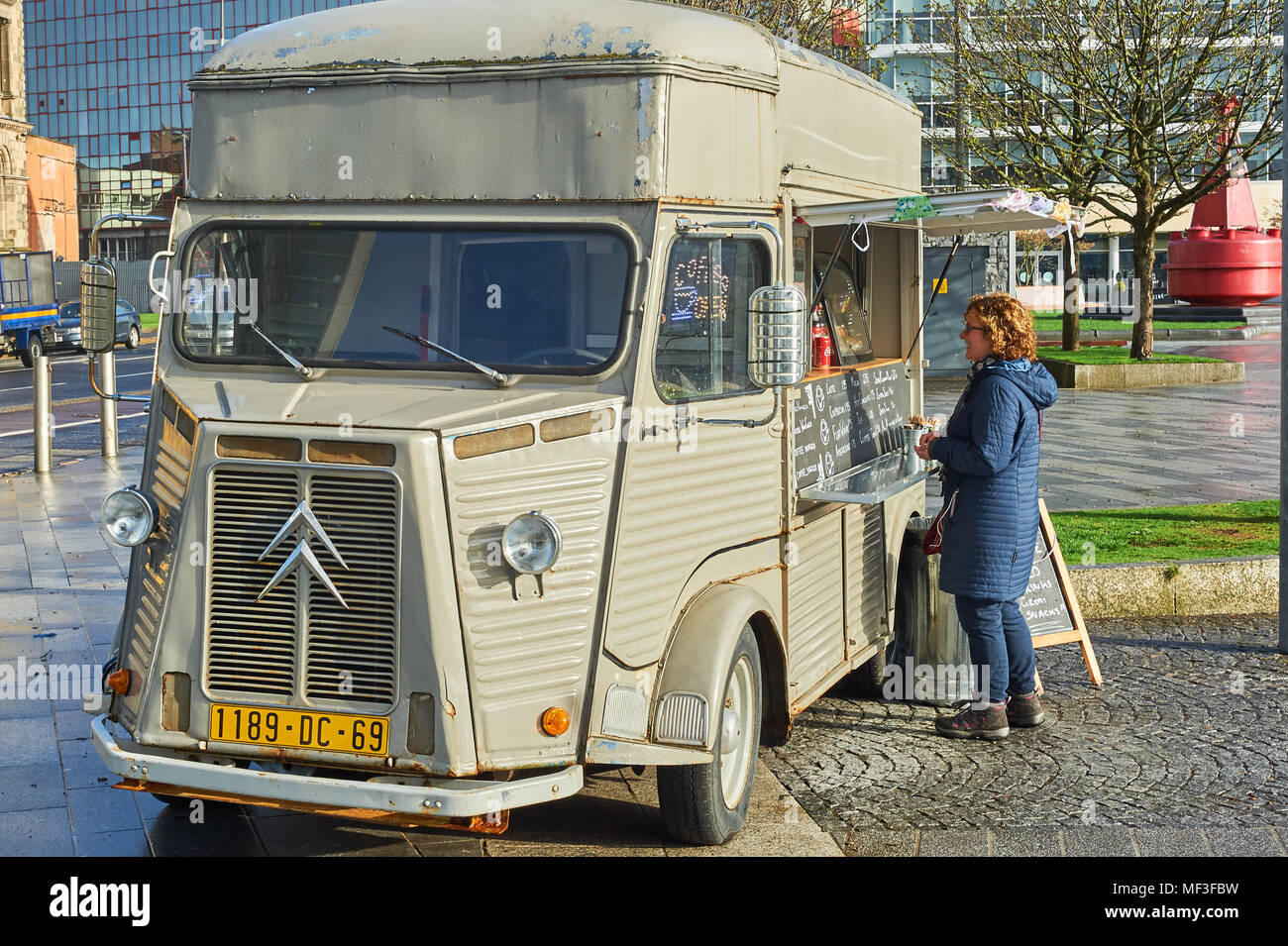 Lady buying coffee from a mobile coffee seller in Belfast city centre Stock Photo