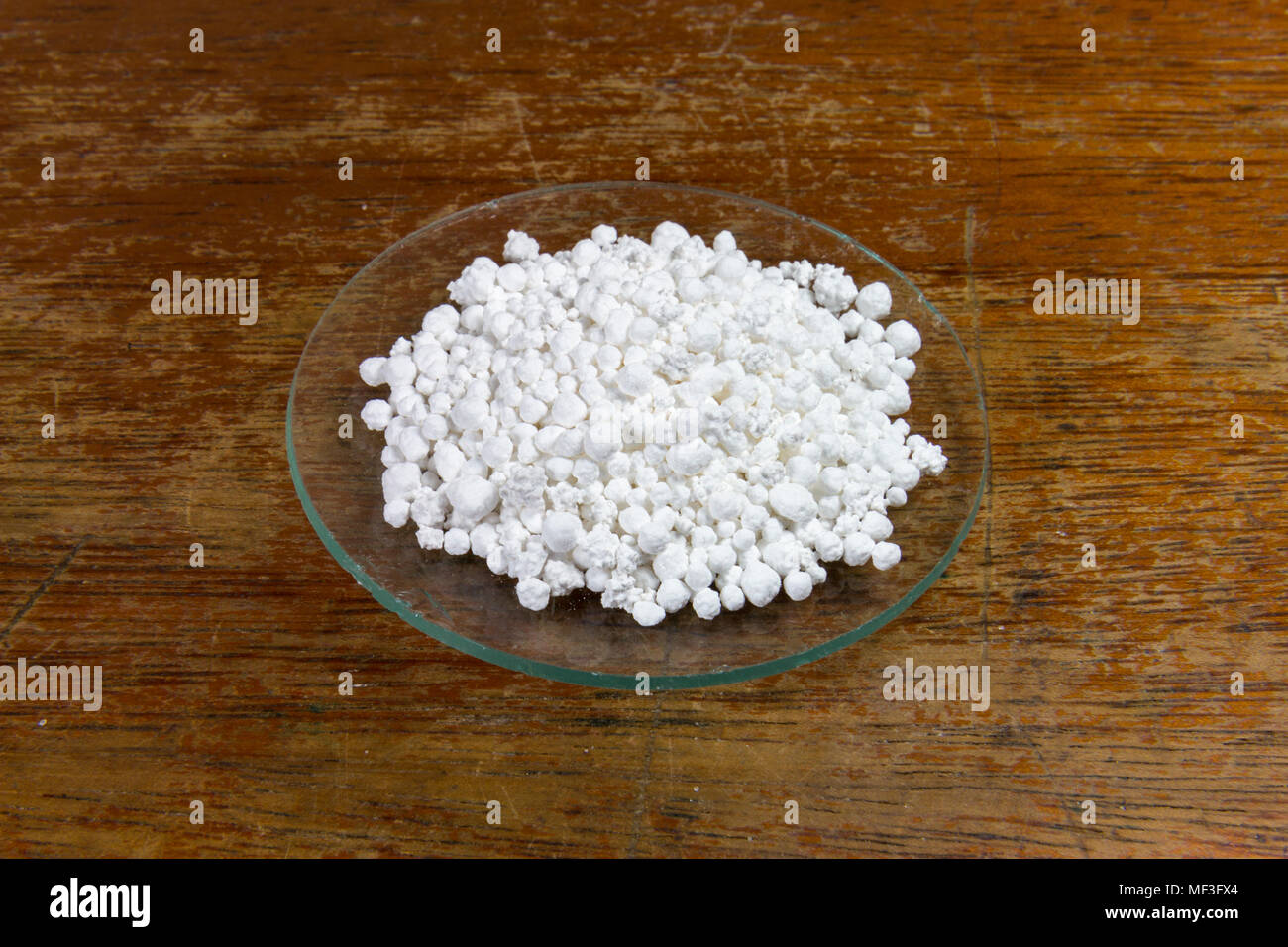 A watch glass of calcium chloride as used in a UK Secondary/High school. Stock Photo