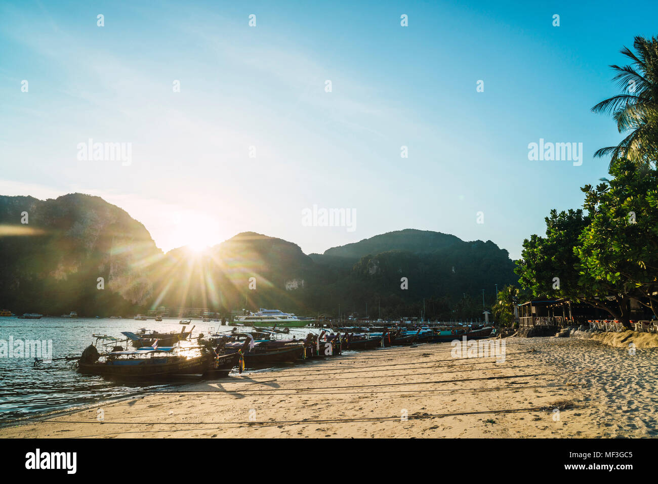 Thailand, Phi Phi Islands, Ko Phi Phi, moored long-tail boats at the beach in backlight Stock Photo