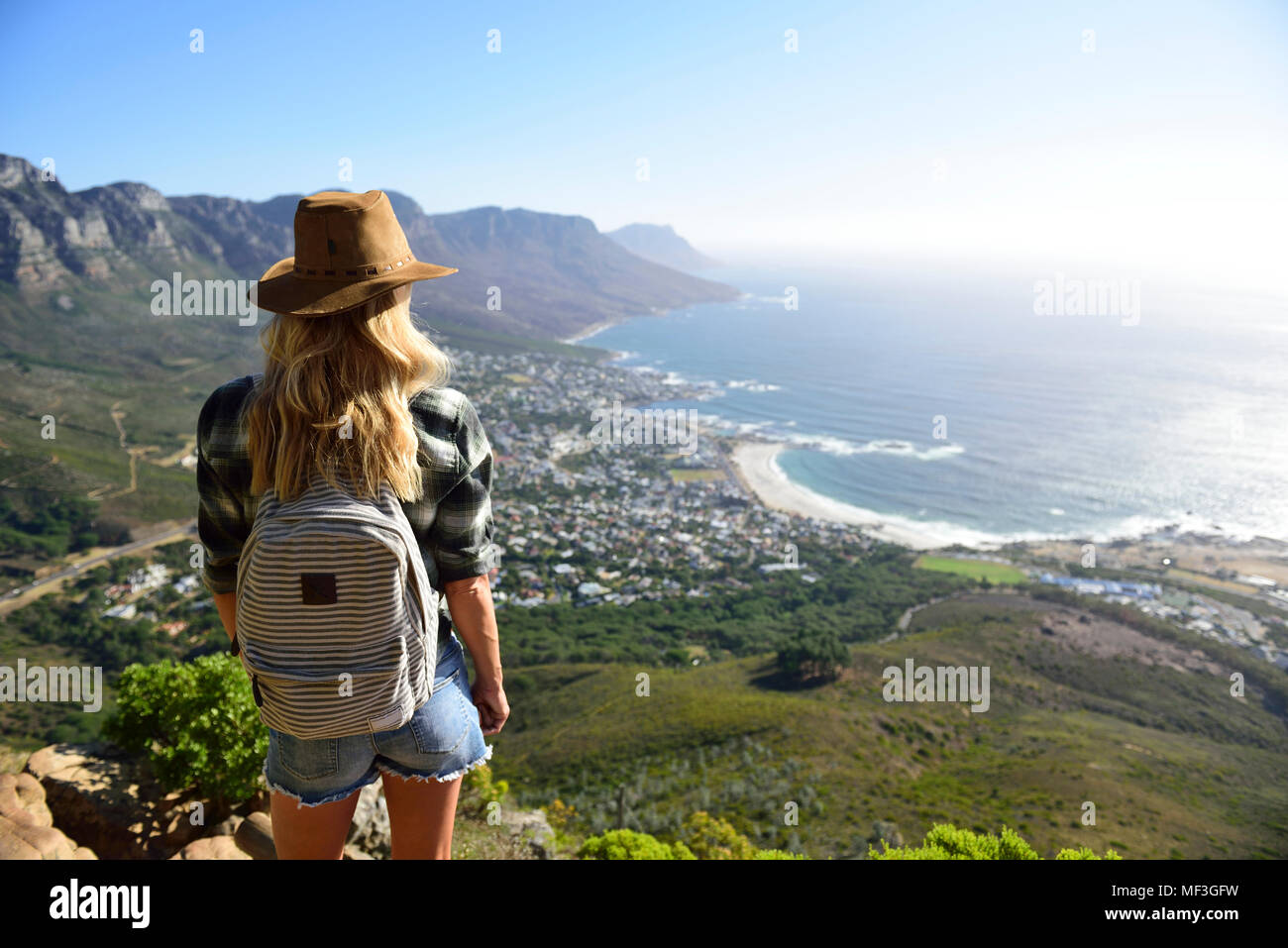 South Africa, Cape Town, woman standing looking at the coast during hiking trip to Lion's Head Stock Photo