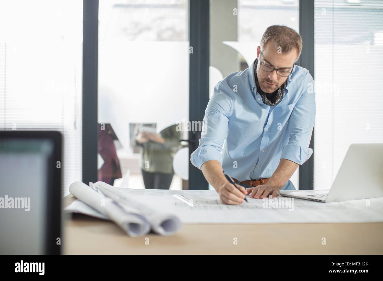 Man making notes on plan in office Stock Photo