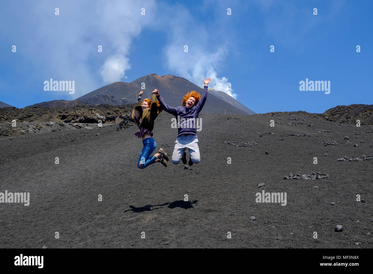 Teenager springen in die Luft, Tanz auf dem Vulkan, Vulkan Ätna, Provinz Catania, Silzilien, Italien, Stock Photo
