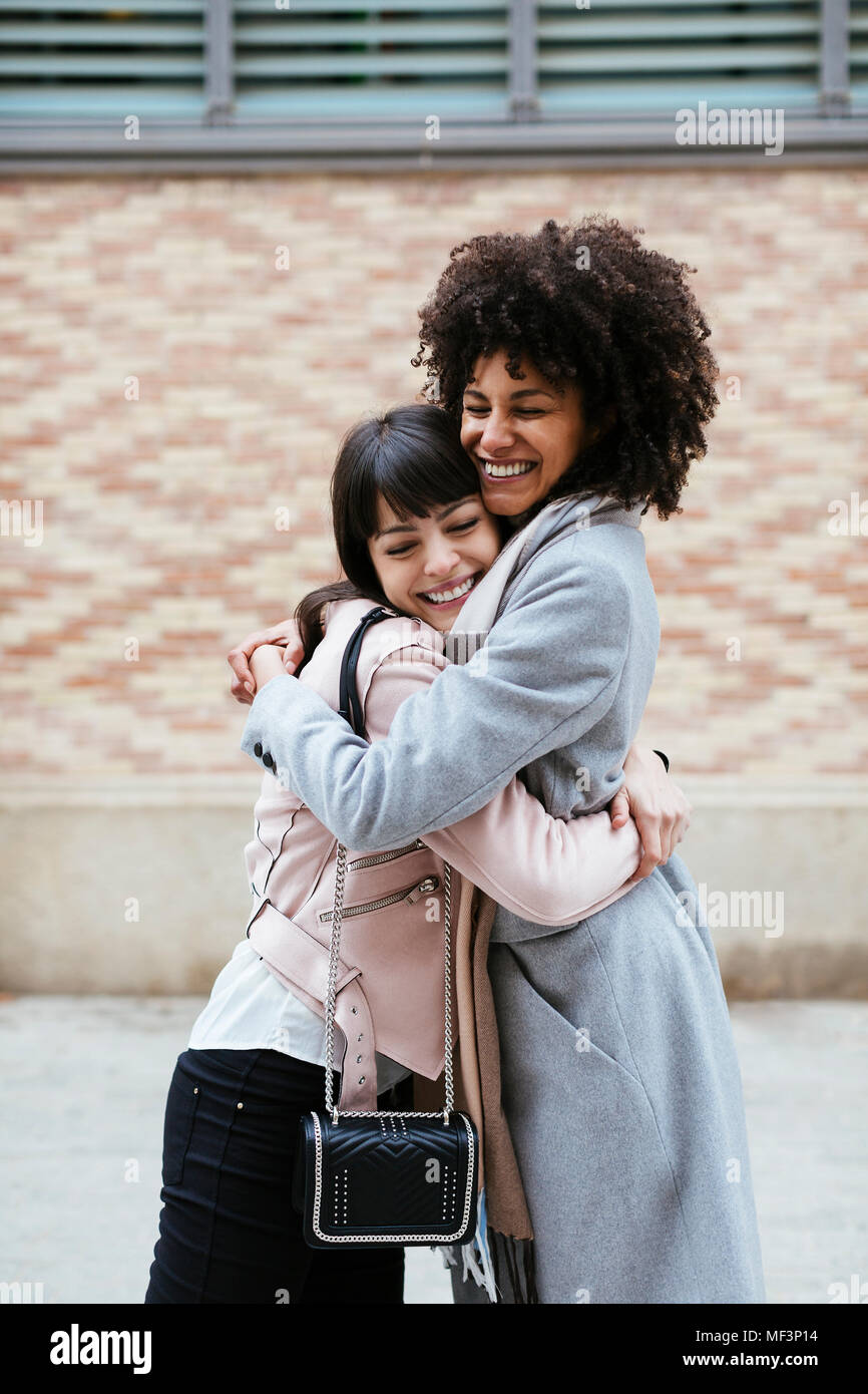 Spain, Barcelona, two happy women embracing in the city Stock Photo