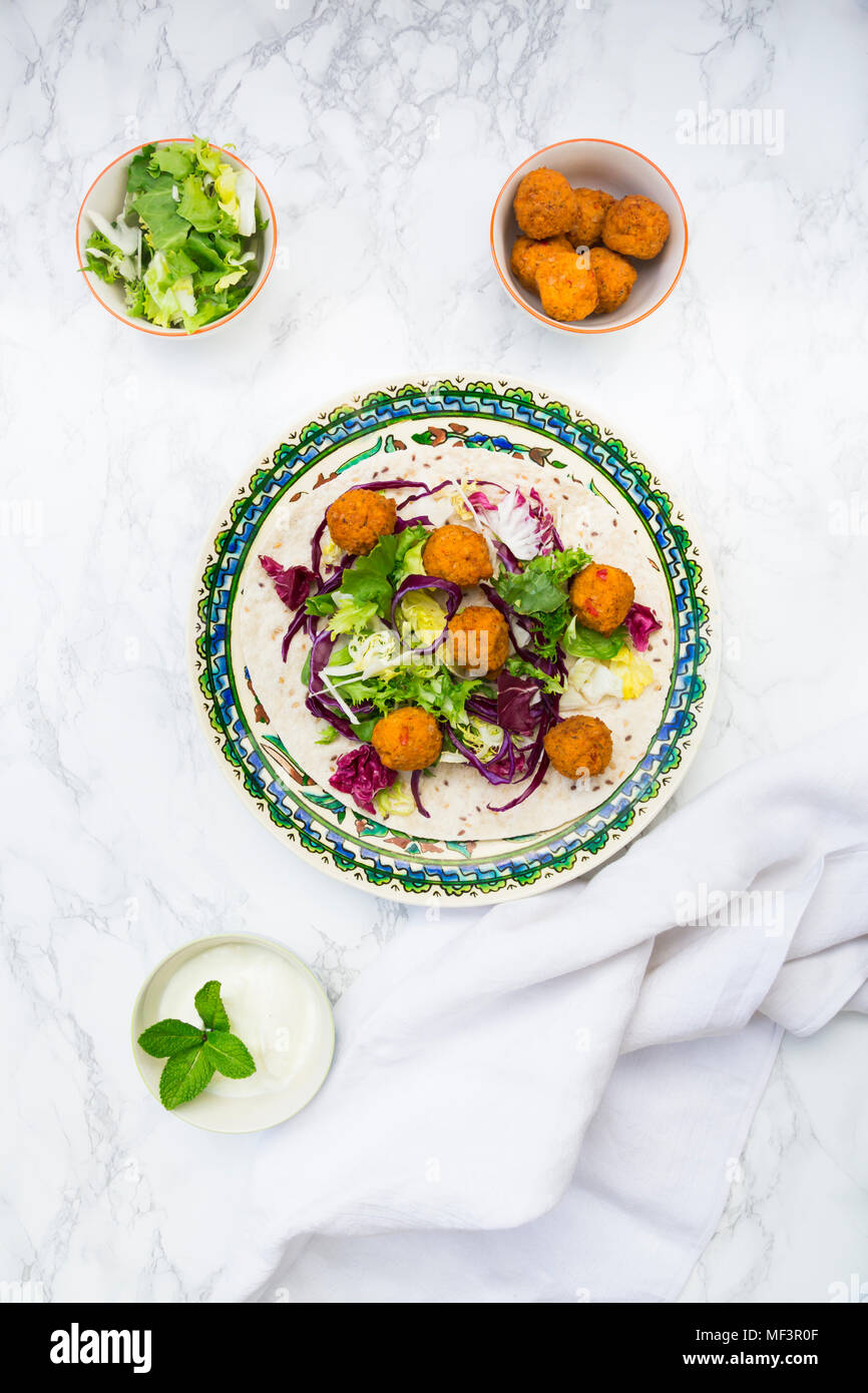 Falafel, wrap, salad, red and white cabbage, yogurt sauce Stock Photo