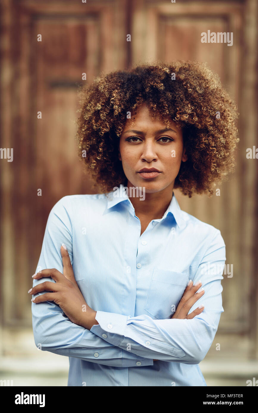 Spain, Andalusia, Malaga. Young black woman, afro hairstyle, in the street. Girl, model of fashion, wearing casual clothes in urban background. Expres Stock Photo