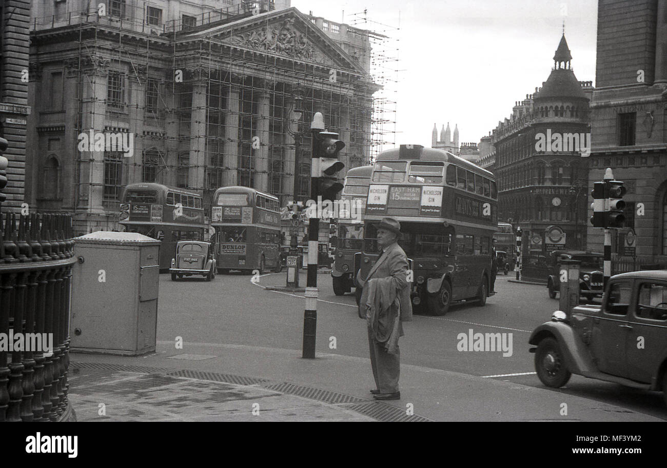 1940s, historical, double-decker route master buses and vehicles of the day, go past the Lord Mayor's official residence, Mansion House, which at the front, has scaffolding on. Stock Photo