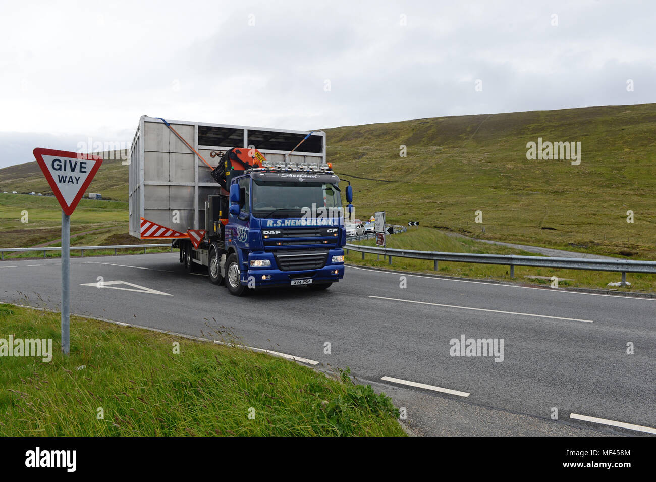 Wide load being moved by a truck through narrow roads Stock Photo