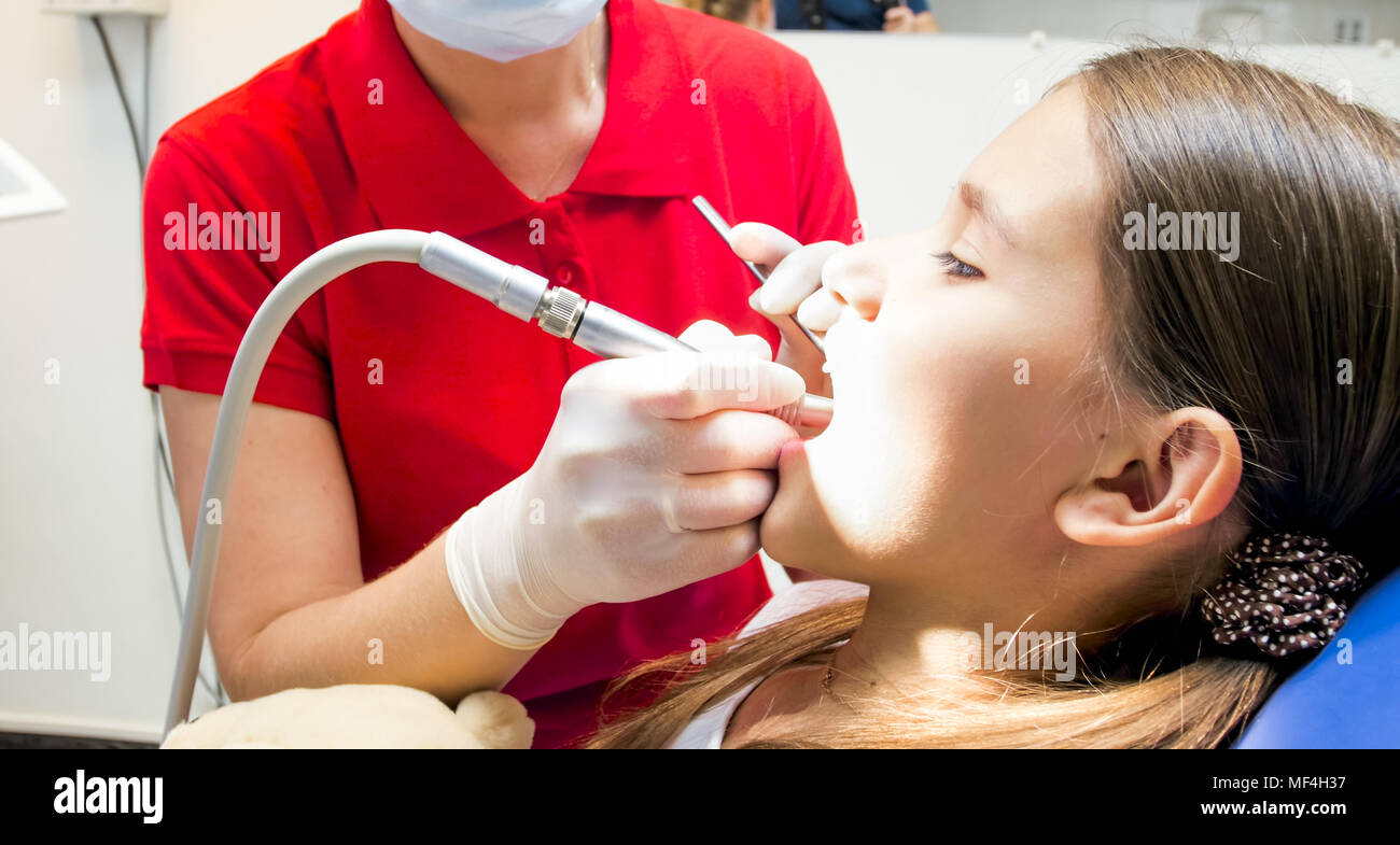 Closeup image of female pediatric dentist treating girls teeth Stock Photo