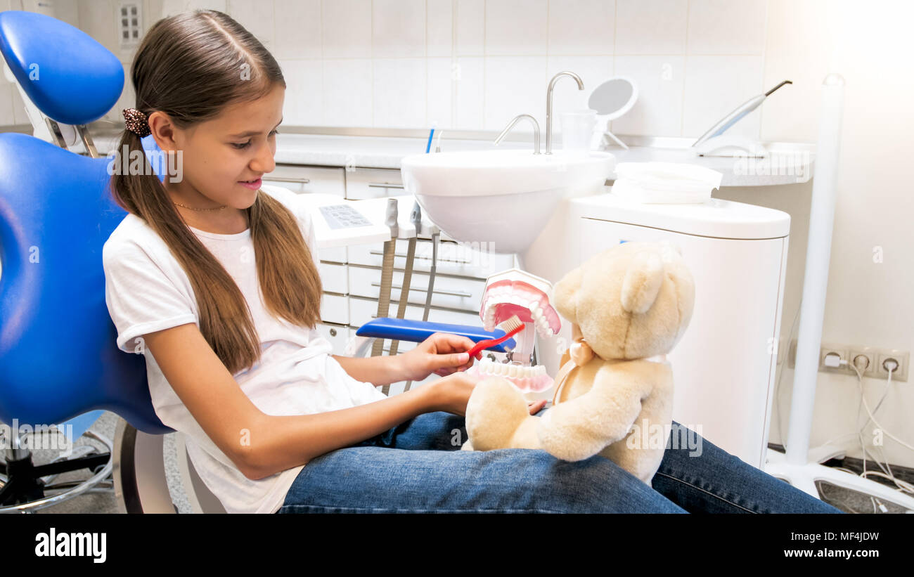 Portrait of little girl with teddy bear playing in dentist office in