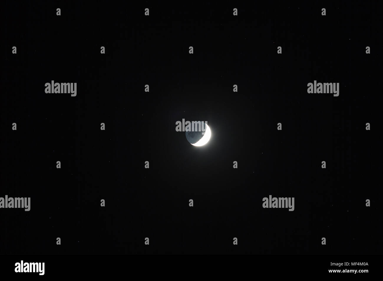 Moon - Waxing Crescent and grey light against dark starry sky background Stock Photo