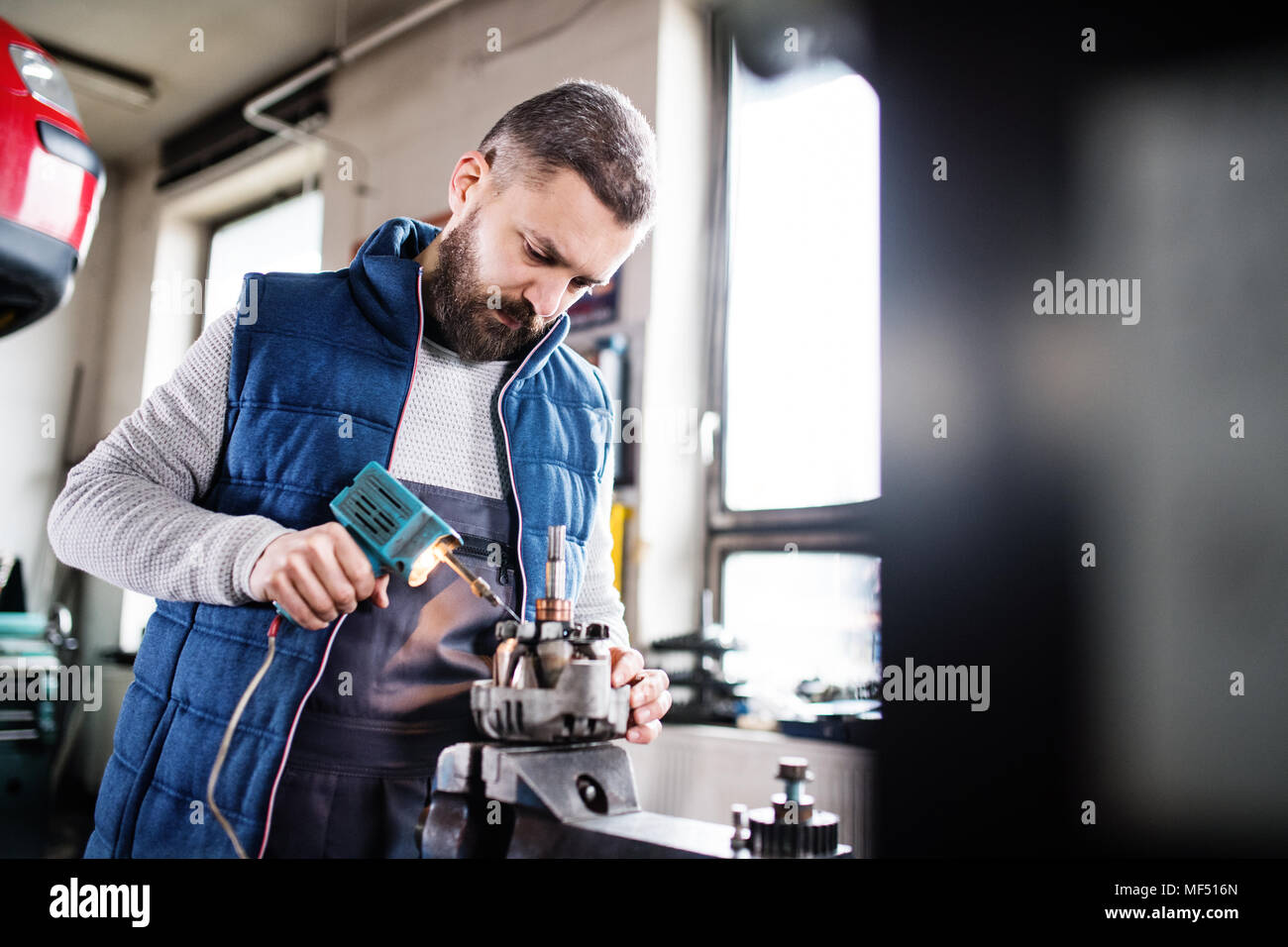 Man mechanic repairing a car in a garage Stock Photo - Alamy