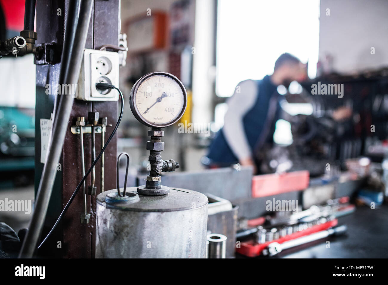 Man mechanic repairing a car in a garage Stock Photo - Alamy