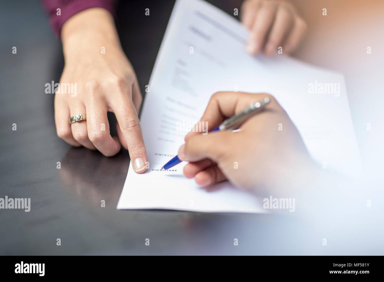 Close-up of signing a document Stock Photo