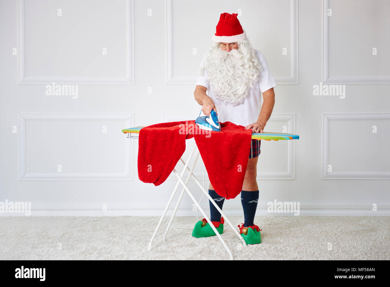 Santa claus ironing his pants Stock Photo