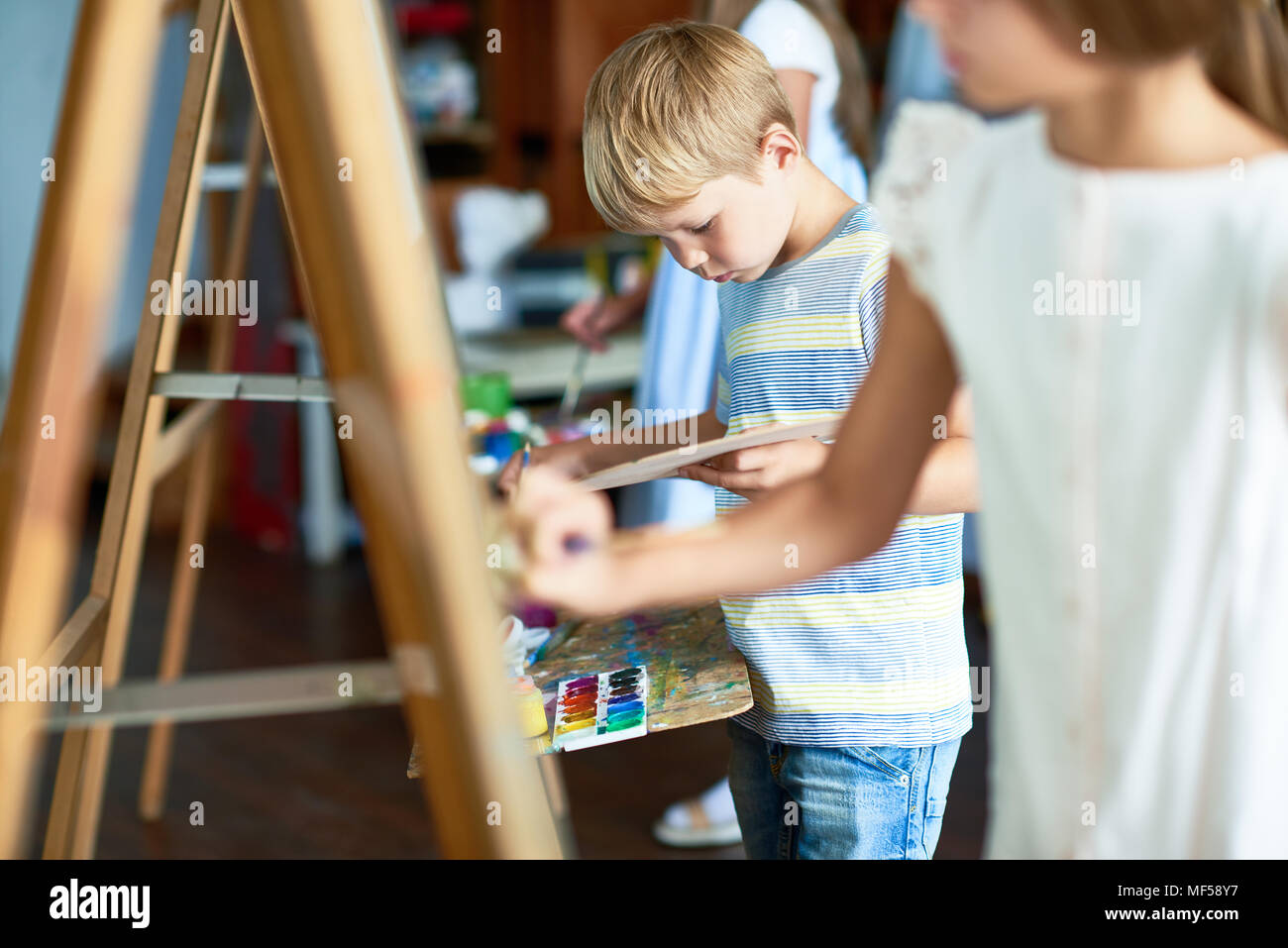 Little Boy Painting in Art Class Stock Photo