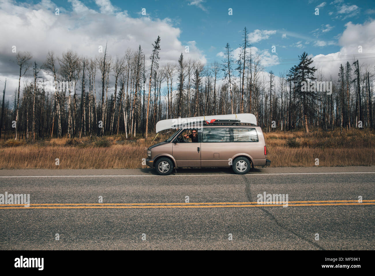 Canada, British Columbia, man with minivan on Alaska Highway Stock Photo